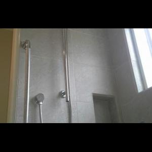 Long handled shower on a slider bar for sit down or stand up use